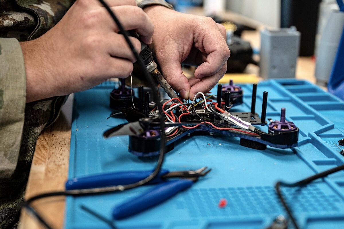 An Air Force technician at the AFCENT Battle Lab assembles a custom-built, 3D-printed quadcopter drone for tactical testing.