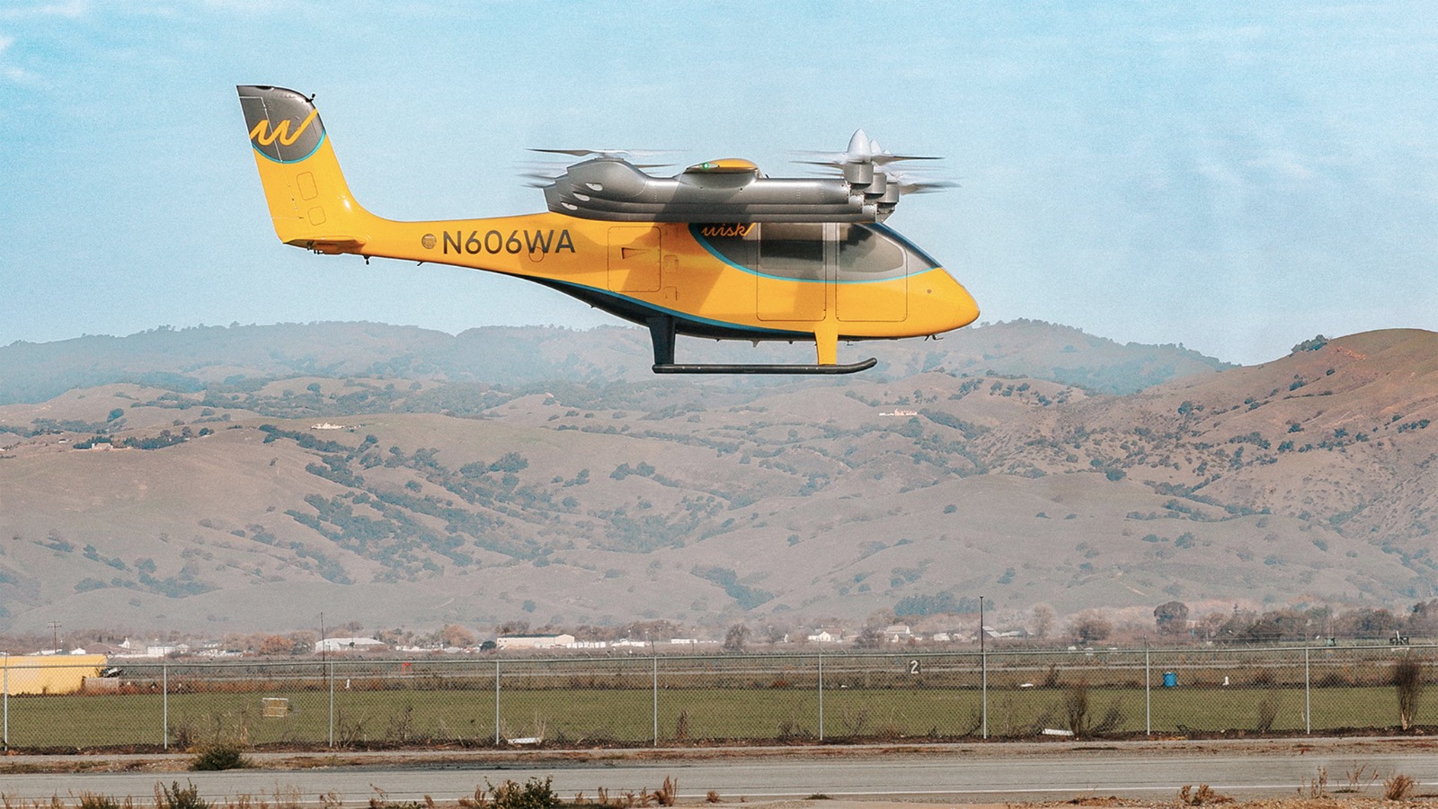 The Wisk Aero Generation 6 autonomous electric air taxi aircraft hovering during its first test flight in California.