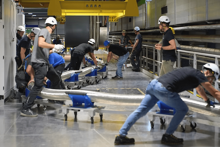Adjusting the superconducting link as it is unspooled into the IT String. (Image: CERN)