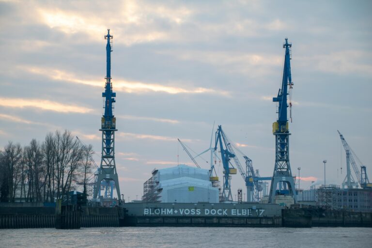 North Korean leader Kim Jong Un inspects a large 8,700-ton submarine hull in red primer at a domestic shipyard.