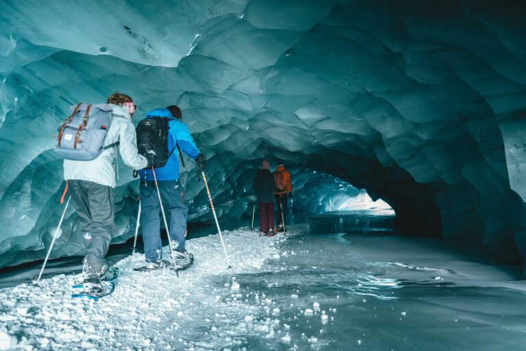 Chinese astronauts wearing headlamps and gear conducting mapping training inside a dark, rocky cave.