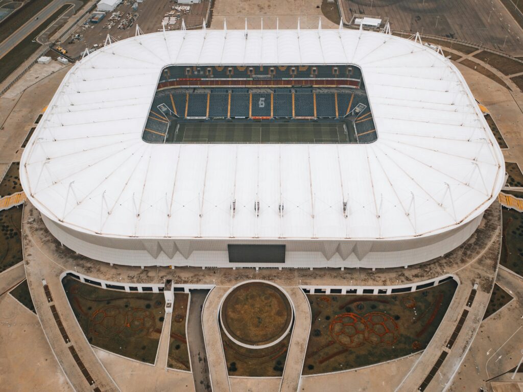Wide shot of a large tournament arena with multiple drone soccer cages