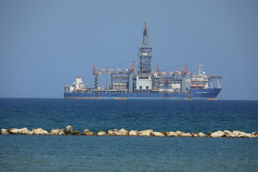 A deep-sea research vessel operates equipment to collect sediment samples from the ocean floor for Japan's rare earth mining project.