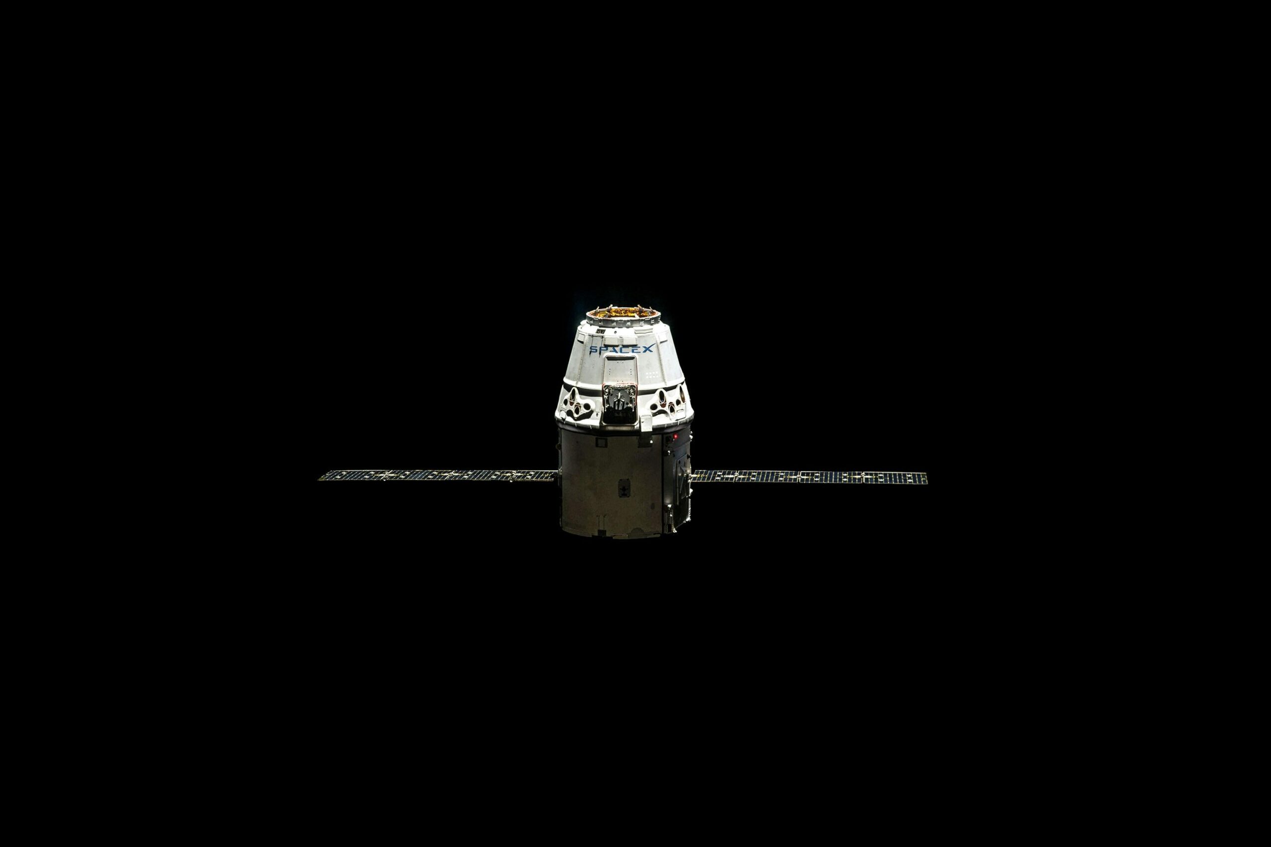 White Boeing Starliner capsule against black space background approaching the International Space Station with Earth visible below